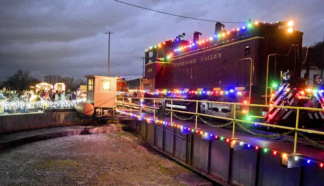 Passengers line the turntable as engine 606 is prepared to be turned at the East Chattanooga Station, on Tuesday, December 28, 2021 in Chattanooga, Tenn., during the The Tennessee Valley Railroad Museum's Holiday Light Train. (Photo by Robin Rudd/Chattanooga Times Free Press via AP Photo)