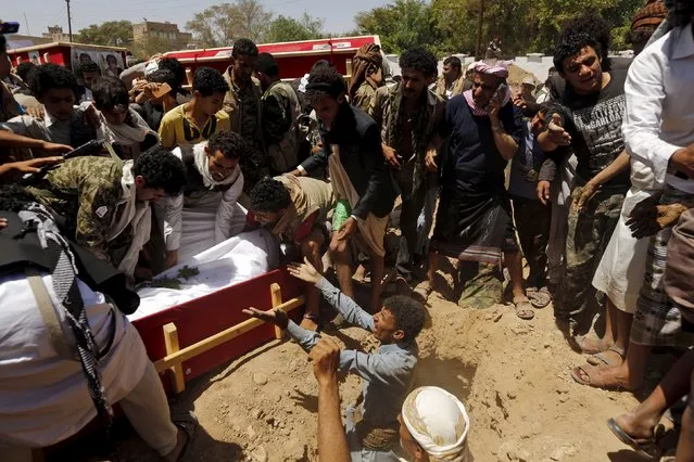 Houthi followers lower the body of a Houthi fighter in a coffin as they bury him in Sanaa May 15, 2015. (Photo by Khaled Abdullah/Reuters)