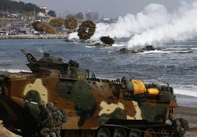 Amphibious assault vehicles of the South Korean Marine Corps throw smoke bombs as they move to land on shore during a U.S.-South Korea joint landing operation drill in Pohang March 31, 2014. The drill is part of the two countries' annual military training called Foal Eagle, which began on February 24 and runs until April 18. (Photo by Kim Hong-Ji/Reuters)