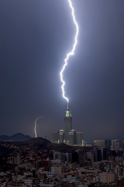 A picture taken on August 22, 2023 shows lightning over Mecca's clock tower in Saudi Arabia. Fierce storms closed schools on August 23 the desert kingdom's Mecca region, home to the holy Grand Mosque which was lashed by heavy rains and wind overnight, witnesses said. (Photo by Hammad Al-Huthali/AFP Photo)