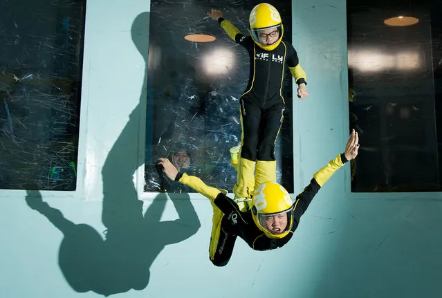 In this picture taken on April 3, 2014, Singaporean competitors take part in a training session ahead of the Bodyflight World Challenge, the worlds largest indoor skydiving competition, at Bodyflight in Bedford. The 36 metre-tall tunnel was originally built in the 1950's as a Royal Aircraft Establishment test facility. 105 teams from all over the globe will take part in the two day formation skydiving event which takes place on April 4–5, 2014. (Photo by Leon Neal/AFP Photo)