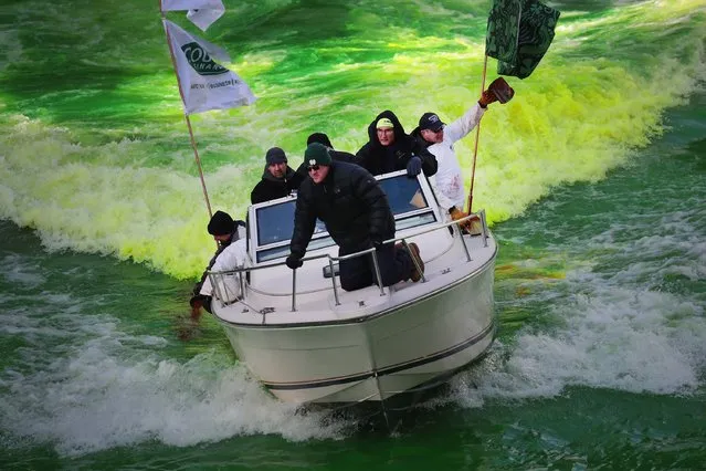 Workers use a boat to mix dye into the Chicago River to turn it green in celebration of St. Patrick's Day on March 11, 2017 in Chicago, Illinois.  Dyeing the river has been a St. Patrick's Day tradition in the city since 1962. (Photo by Scott Olson/Getty Images)