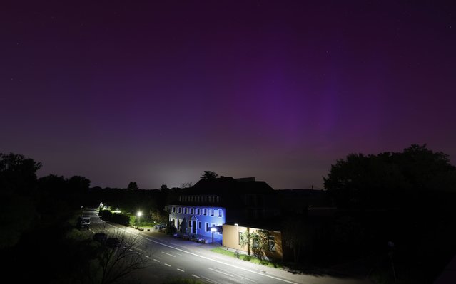 The Northern Lights shine above a blue hotel in Speyer, Germany, 11 May 2024. (Photo by Ronald Wittek/EPA)