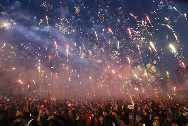 Protesters set off fireworks during a candle light vigil calling for impeached President Park Geun-hye's arrest in Seoul, South Korea, Saturday, March 11, 2017. South Korean police on Saturday braced for more violence between opponents and supporters of ousted President Park Geun-hye, who was stripped of her powers by the Constitutional Court over a corruption scandal that has plunged the country into a political turmoil. (Photo by Ahn Young-joon/AP Photo)
