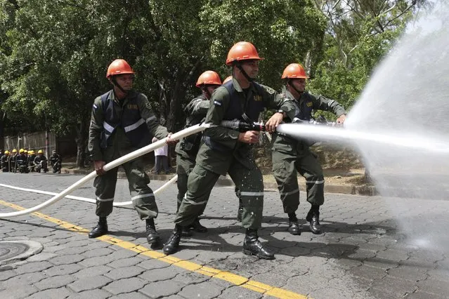 Members of Nicaragua's army put out flames during an earthquake drill at Managua, Nicaragua June 30, 2015. (Photo by Oswaldo Rivas/Reuters)
