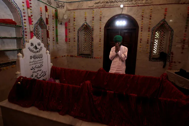 A man says a prayer over the grave of Mumtaz Qadri at the shrine built over his grave outside Islamabad, Pakistan February 27,  2017. (Photo by Caren Firouz/Reuters)