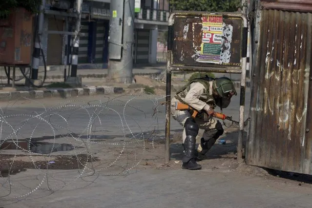 An Indian paramilitary soldier crosses a barbwire checkpoint set up as road barricade during lockdown in Srinagar, Indian controlled Kashmir, Friday, August 23, 2019. The latest crackdown began just before Prime Minister Narendra Modi's Hindu nationalist-led government stripped Jammu and Kashmir of its semi-autonomy and its statehood, creating two federal territories. (Photo by Dar Yasin/AP Photo)
