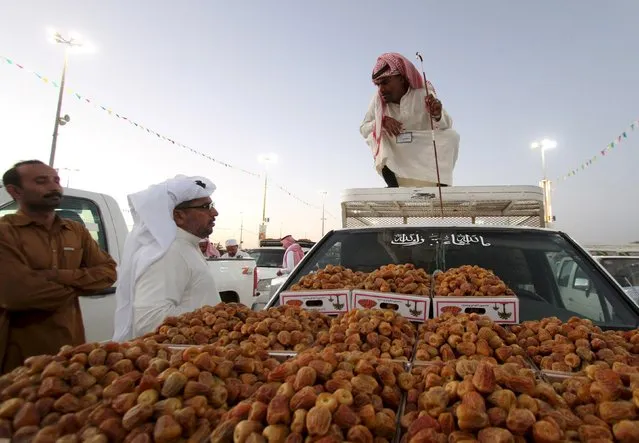 A vendor selling dates sits atop a pick-up truck as he talks to customers during the annual dates festival in Berida of the Saudi central province of Qassim, August 14, 2015. (Photo by Faisal Al Nasser/Reuters)