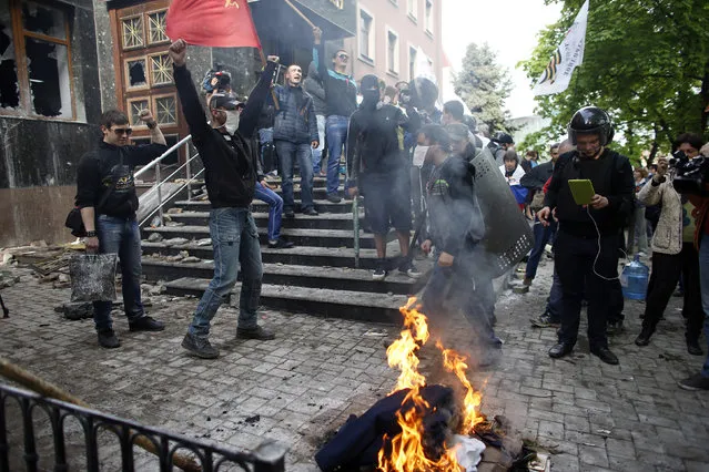 Pro-Russian activists burn uniforms outside the prosecutor's office in Donetsk May 1, 2014. Pro-Russian protesters stormed the prosecutor's office in the separatist-held city of Donetsk on Thursday, lobbing petrol bombs and stones, Interfax-Ukraine news agency reported. (Photo by Marko Djurica/Reuters)