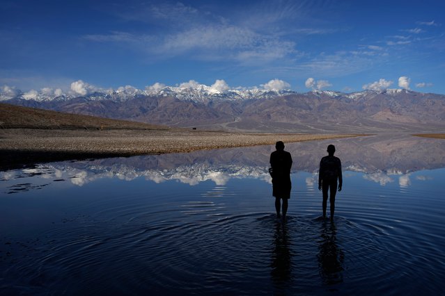 Vijay Parthasarathy, left, and Vinaya Vijay wade into water at Badwater Basin, Thursday, February 22, 2024, in Death Valley National Park, Calif. The basin, normally a salt flat, has filled from rain over the past few months. (Photo by John Locher/AP Photo)
