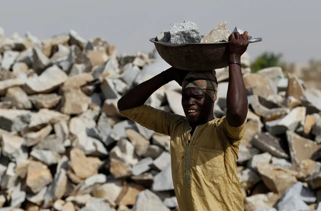 A man carries a headpan filled with pieces of rock at a granite crushing plant near a gold mine in Zamfara, Nigeria April 21, 2016. (Photo by Afolabi Sotunde/Reuters)