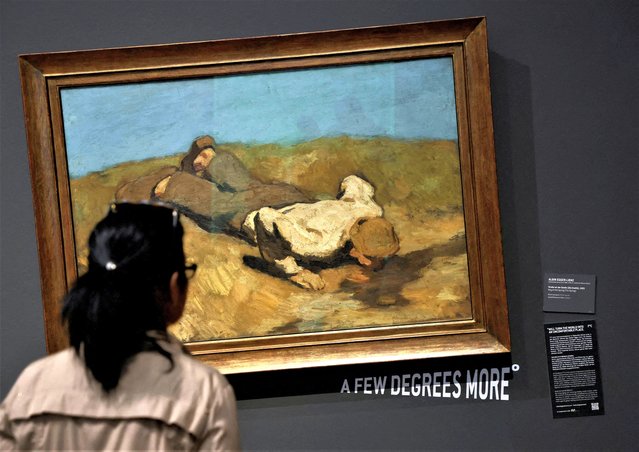 A visitor of the Leopold museum looks at the painting “A boy at the spring” by Albin Egger Lienz after the museum tilted 15 of its paintings in protest of climate change in Vienna, Austria on March 22, 2023. (Photo by Leonhard Foeger/Reuters)