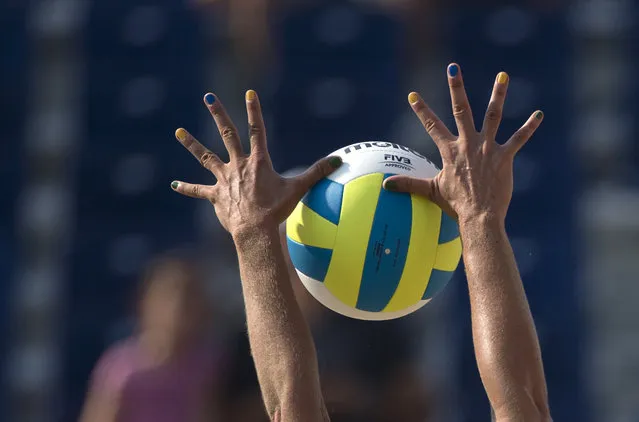 Brazil's Liliane Maestrini, with her fingernails painted in the colors of the national flag, blocks the ball, during Brazil's beach volleyball preliminary match against Nicaragua at the Pan Am Games in Toronto, Monday, July 13, 2015. (Photo by Rebecca Blackwell/AP Photo)