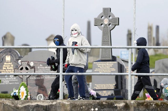 Masked youth with petrol bombs are seen as Republican protesters opposed to the Good Friday Agreement parade in Londonderry, Northern Ireland, Monday, April 10, 2023. President Biden is due to visit Northern Ireland and Ireland to celebrate the 25th Anniversary of the Good Friday Agreement. (Photo by Peter Morrison/AP Photo)