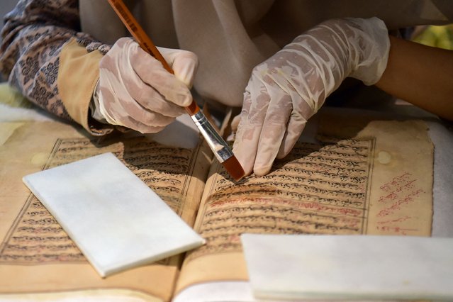 A worker uses preservation techniques on part of an old copy of the Koran, Islam's holy book, at the Museum of Islamic Cultural Heritage, which exhibits dozens of Koran scriptures estimated to be dated from 150 to 1,000 years old, in Yingor district in the southern Thai province of Narathiwat on June 13, 2024. (Photo by Madaree Tohlala/AFP Photo)