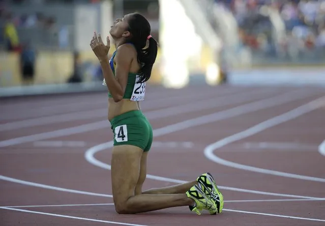 Brazil's Erika Lima kneels on the ground after competing in the semifinals of the women's 800 meter run at the Pan Am Games in Toronto, Tuesday, July 21, 2015. (Photo by Mark Humphrey/AP Photo)