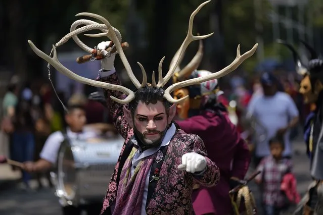 A costumed Indigenous man that lives in Mexico City, dances during a march in recognition of the International Day of the World's Indigenous Peoples, Monday, August 9, 2021. (Photo by Eduardo Verdugo/AP Photo)