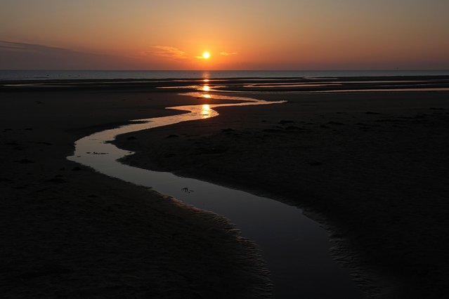 Sun rises over Omaha Beach near Colleville-sur-Mer Normandy, Thursday, June 6, 2024. (Photo by Laurent Cipriani/AP Photo)