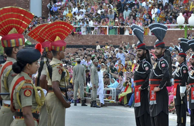 Indian Border Security Force soldiers, left, and Pakistani Rangers, in black, stand face-to-face during the daily retreat ceremony at the India-Pakistan joint border check post of Attari-Wagah near Amritsar, India, Tuesday, July 21, 2015. Tension has mounted between India and Pakistan following a series of firefights and shelling in the past week along their border in the disputed Kashmir region. (Photo by Prabhjot Gill/AP Photo)