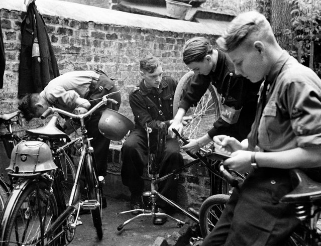 Members of the Hitler Youth who are trained to report airstrikes repaining their bicycles. Published by: “Die Sirene”. 1942. (Photo by Herbert Hoffmann/Ullstein Bild via Getty Images)