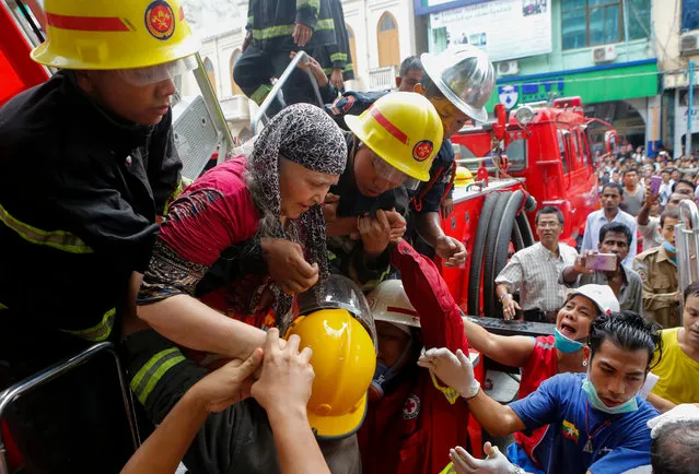 An elderly person is being rescued by fire fighters during a fire that broke out in Yangon, Myanmar, 05 June 2016. No injuries or casualties were reported in the fire that broke out at a six-storey building in the downtown area of Yangon. (Photo by Lynn Bo Bo/EPA)