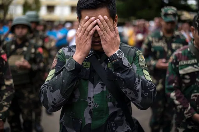 A soldier prays during a flag raising ceremony at the Lanao Del Sur provincial capital of Marawi on the southern island of Mindanao on June 12, 2017. Embattled Philippine troops struggling to force out Islamist militants from a southern city raised the national flag for Independence Day on June 12, in a tearful ceremony dedicated to the scores killed during the conflict. (Photo by Noel Celis/AFP Photo)