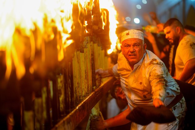 People lit torches and sing along laments in a mourning ritual to commemorate Prophet Mohammed's grandson Imam Hussein and his 72 loyal companions, who died at the battle of Karbala, during the month of Muharram on the Islamic calendar in Najaf, Iraq on July 14, 2024. (Photo by Karar Essa/Anadolu via Getty Images)