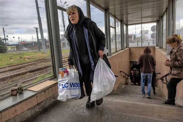 A woman displaced by Russian shelling departs a metro station where people had been living underground for months on May 22, 2022 in Kharkiv, Ukraine. Authorities plan to restart the Kharkiv subway system on May 24 and are providing temporary shelter in student dormitories for those made homeless by Russian attacks. Although Russian shelling has largely ceased in Kharkiv, it continues in the northern suburbs, and many houses and large apartment buildings in the city are destroyed, leaving thousands homeless. (Photo by John Moore/Getty Images)