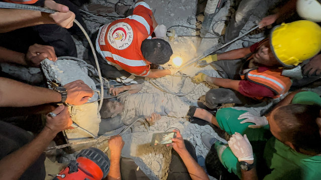 Palestinians work to rescue a child from under the rubble following an Israeli strike, amid the Israel-Hamas conflict, in Nuseirat in the central Gaza Strip, on September 12, 2024. (Photo by Hatem Hani/Reuters)