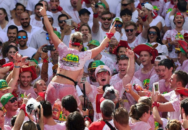 Revelers celebrate during the “Chupinazo” (start rocket) to mark the kickoff at noon sharp of the San Fermin Festival, in front of the Town Hall of Pamplona, northern Spain, on July 6, 2017. (Photo by Miguel Riopa/AFP Photo)