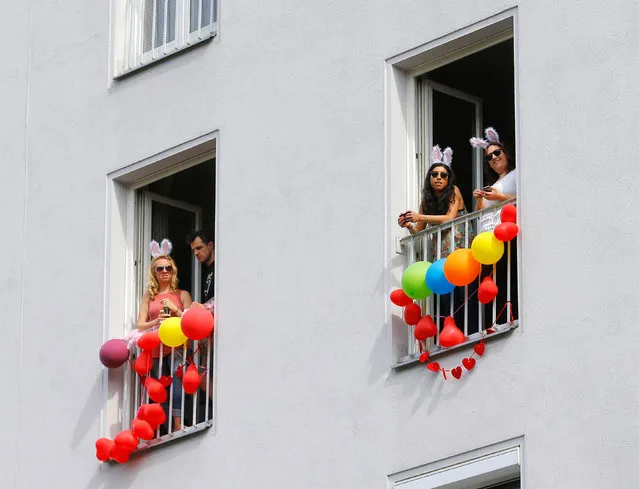 People watch Regenbogenparade gay pride parade from windows of an apartment house in Vienna, Austria, June 18, 2016. (Photo by Heinz-Peter Bader/Reuters)