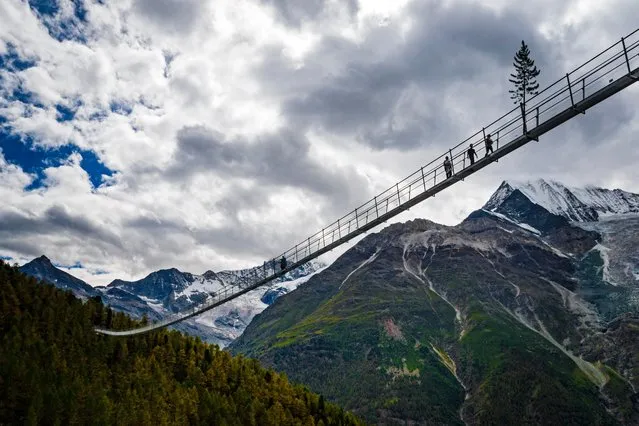 People walk on the “Europabruecke” bridge, the world's longest pedestrian suspension bridge with a length of 494m, after the official inauguration of the construction in Randa, Switzerland, 29 July 2017. The bridge is situated on the Europaweg that connects the villages of Zermatt and Graechen. (Photo by Valentin Flauraud/EPA)