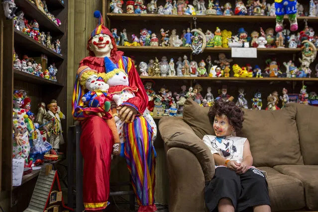 Kai James, 9, glances over at the life-size clown known as “Mr. Creepy” in the lobby of the Clown Motel in Tonopah on Tuesday, July 25, 2017. James came with his brother and mother from Las Vegas to stay for a night and dressed up in clown attire. (Photo by Patrick Connolly/Las Vegas Review-Journal via AP Photo)