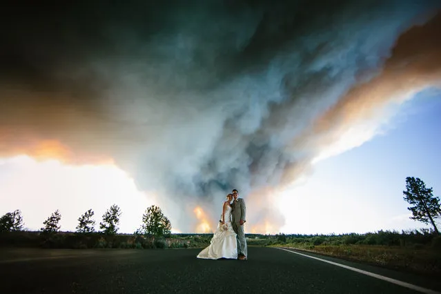 Wedding photographer, Josh Newton, has managed to turn a natural disaster into an amazing photo shoot opportunity. On June 7, 2014 Michael Wolber and April Hartley were getting ready to walk down the aisle in Rock Springs Ranch, Bend, Oregon, USA when firefighters alerted them to nearby wildfires gaining momentum and instructed them to flee to a safer location. (Photo by Josh Newton/IMP)