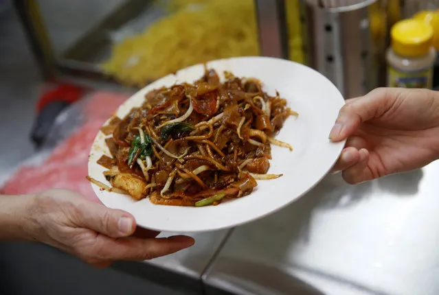 A plate of Char Kuay Teow (fried noodles) is collected by a customer at a hawker centre in Singapore May 21, 2016. (Photo by Edgar Su/Reuters)