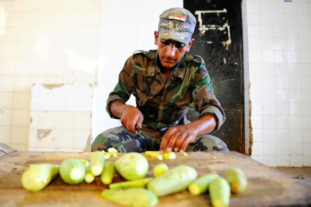 A new Syrian army recruit prepares food for the Iftar (breaking fast) meal, at a military training camp in Damascus, Syria June 26, 2016. (Photo by Omar Sanadiki/Reuters)