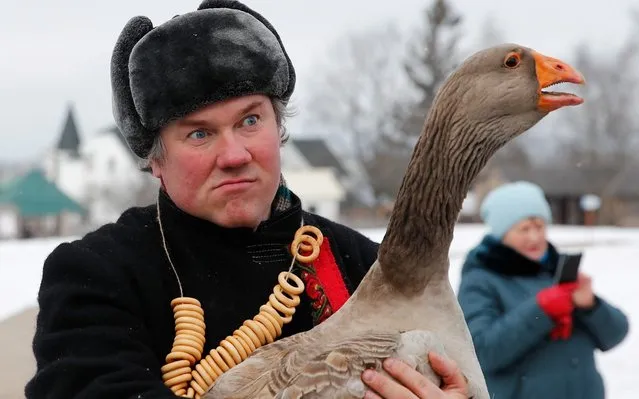 A man wearing a traditional Russian costume holds a goose after a traditional goose fight during celebrations of Maslenitsa, also known as Pancake Week, which is a pagan holiday marking the end of winter, in Suzdal, Russia on February 29, 2020. (Photo by Maxim Shemetov/Reuters)