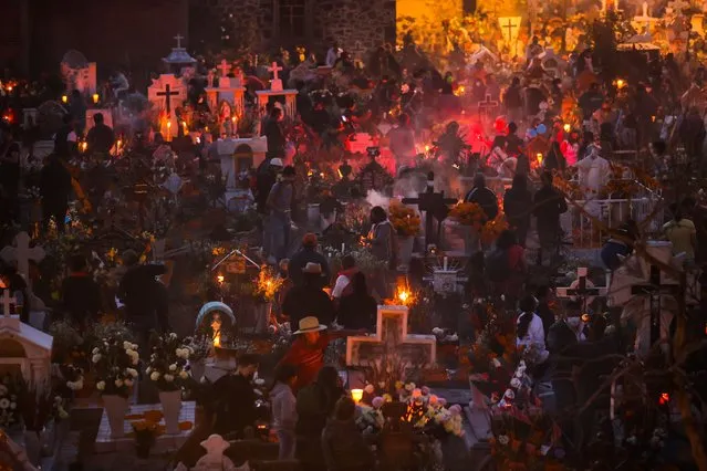 General view of the pantheon of San Andres Mixquic as part of the 2021 “Day of The Dead” celebration on November 02, 2021 in Mexico City, Mexico. Considered one of the most popular celebrations in Mexico, the Day of the Dead takes place every year on November 1 and 2. People remember those who have died with offerings, family gatherings and visits to their graves. The celebration has expanded to other countries in Latin America and the rest of the world. After the 2020 restrictions due to the Covid-19 pandemic, this year Mexican authorities will allow people to visit cemeteries by following protocols. (Photo by Hector Vivas/Getty Images)