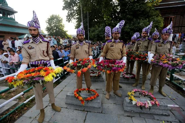 Indian policemen wearing ceremonial dress carry wreaths during an event at the Martyrs Graveyard to mark “Martyrs Day” in Srinagar July 13, 2016. On July 13, 1931, dozens of Kashmiris were gunned down by police during a protest against the Hindu Maharaja Hari Singh, then ruler of the Himalayan region. The Kashmir state government also observes the day as Martyrs Day and has declared July 13 a holiday. (Photo by Danish Ismail/Reuters)