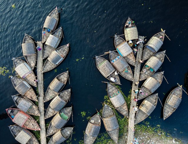 These moored boats, which were shaped in such a way that looked like of branches on a tree. The boats were moored on the Shitalakshya River in Narayanganj, Bangladesh on August 9, 2022 and are used to carry passengers from one side of the river. A boatman cannot carry passengers across the river whenever he wishes. They must maintain an order, controlled using ticket numbers. After completing one trip across the river, the boat moves to the back of the queue and gets a new number. When his number is called up again, only then can he carry passengers across. (Photo by Mustasinur Rahman Alvi/Rex Features/Shutterstock)