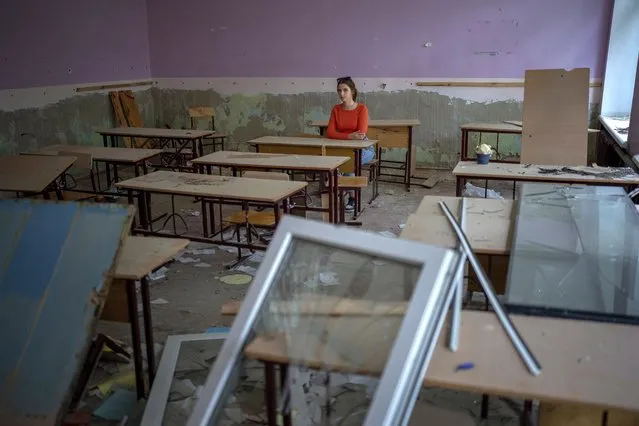 Surrounded by shards of broken glass and rubble 14-year-old Sofia Zhyr, sits at her desk in the remains of her classroom in the Chernihiv School #21, which was bombed by Russian forces on March 3, in Chernihiv, Ukraine, Tuesday, August 30 , 2022. “I was scared to come to the school the first time after it was bombed. For a long time, I was just looking at it from afar. At those moments, it seemed like nothing ever happened”. Sofia said. Scraping through the rubble of the classroom they last saw on February 24 – at the start of the Russian invasion – one group of children returned to the remains of their bombarded school on Tuesday to check the condition of their school. (Photo by Emilio Morenatti/AP Photo)