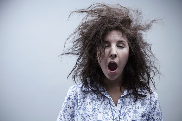 Young woman yawning, close up. (Photo by David Zach/Getty Images)
