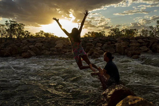A girl is seen jumping from rocks at Brewarrina Weir on February 16, 2020 in Brewarrina, Australia. The Brewarrina Weir in Northern New South Wales overflowed on the weekend for the first time in years, as rain water from upstream flowed into the once dry river beds. The influx of water at the weir has also brought back to life the heritage listed Aboriginal fish traps, also known as Baiame's Ngunnhu. Recent rains and thunderstorms across Eastern Australia have seen a number of rivers feeding the Murray-Darling basin begin to flow. Pumping embargoes for the Barwon-Darling river system which prevent irrigators from extracting water from the river are currently in place, however there are fears that recent rainfalls may cause the NSW Government to lift the ban. (Photo by Jenny Evans/Getty Images)