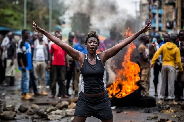 An opposition supporter reacts under the heavy rain in front of a burning barricade in Mathare district, in Nairobi on October 26, 2017, as a group of demonstrators blocked the road and tried to prevent voters from accessing a polling station during presidential elections.
Kenyans trickled into polling stations on October 26 for a repeat election that has polarised the nation, amid sporadic clashes as supporters of opposition leader ignored his call to stay away and tried to block voting. (Photo by Luis Tato/AFP Photo)
