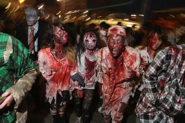 Zombie enthusiasts set out on a “Zombie Walk” in the city center on October 27, 2012 in Berlin, Germany. Approximately 150 zombies, who had organized themselves through Facebook, walked and limped across Alexanderplatz, growled and moaned at passersby and performed jerking dances. (Photo by Sean Gallup)