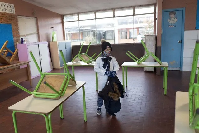 A student enters his public school classroom for the first time in three months since the lockdown to curb the spread of the new coronavirus pandemic in Montevideo, Uruguay, Monday, June 15, 2020. Some children in urban areas returned to school Monday. (Photo by Matilde Campodonico/AP Photo)