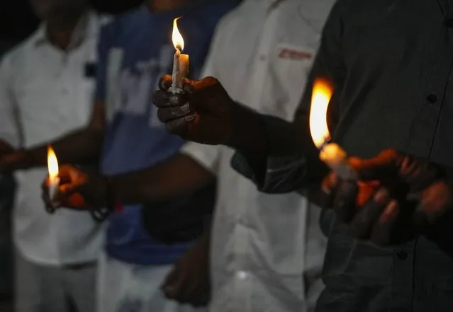People light candles to pay tribute to victims of Sunday's bridge collapse in Morbi town, in the western Indian state of Gujarat, Monday, October 31, 2022. Military teams were searching Monday for people missing after a 143-year-old suspension bridge collapsed into a river Sunday in the western Indian state of Gujarat, sending hundreds plunging into the water and killing at least 133 in one of the country's worst accidents in years. (Photo by Rafiq Maqbool/AP Photo)