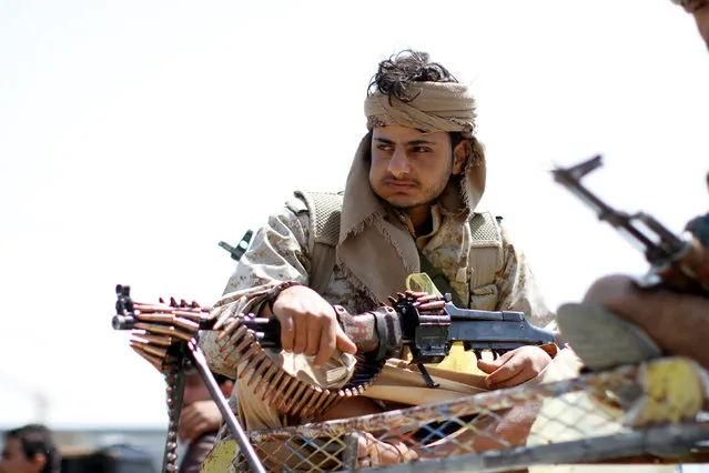 An armed man loyal to the Houthi movement holds his weapon as he rides on the roof of a truck during a protest against the Saudi-backed exiled government deciding to cut off the Yemeni central bank from the outside world, in the capital Sanaa, Yemen August 25, 2016. (Photo by Mohamed al-Sayaghi/Reuters)