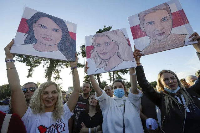People hold portraits of Svetlana Tikhanovskaya, candidate for the presidential elections, left, wife of non-registered candidate Valery Tsepkalo, Veronika Tsepkalo, centre, Maria Kolesnikova, a representative of Viktor Babariko, right, during a meeting in Borisov, Belarus, Thursday, July 23, 2020. The longtime leader of Belarus President Alexander Lukashenko warned Thursday that Western media could be expelled from the country over what he described as their “tendentious” coverage of the presidential election next month in which he is seeking a sixth term. The presidential election in Belarus is scheduled for August 9, 2020. (Photo by Sergei Grits/AP Photo)