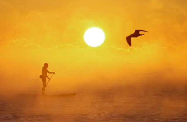 A paddle boarder makes their way through the sea mist as the sun rises over Avon Beach in Dorset on Thursday, December 8, 2022. The Met Office has issued a number of weather warnings for snow and ice for parts of Scotland, Northern Ireland, Wales and the east coast and south-west England over the coming days. (Photo by Andrew Matthews/PA Images via Getty Images)